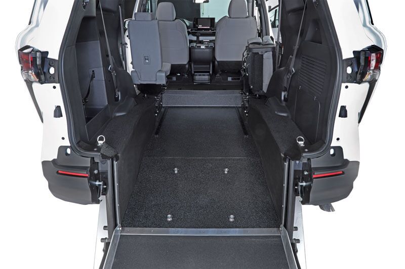 Rear-Entry view of a Toyota Sienna Hybrid wheelchair-accessible van, featuring a lowered floor and ramp, two front seats, and an open space for wheelchair placement.